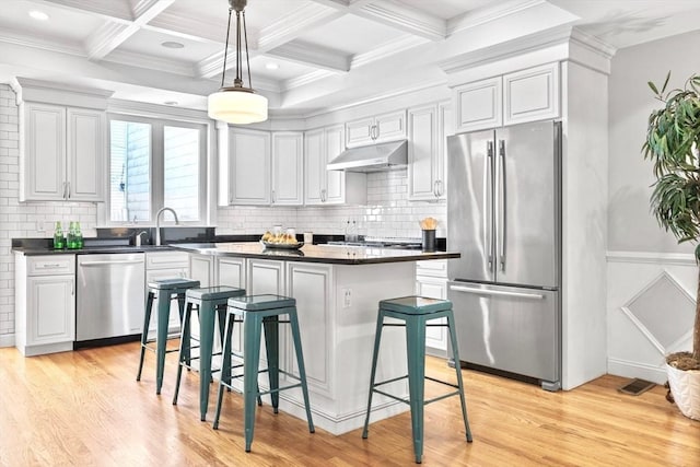49 Baldwin St Unit 1, Boston, MA 02129 - kitchen with stainless steel appliances, under cabinet range hood, dark countertops, light wood finished floors, and beamed ceiling