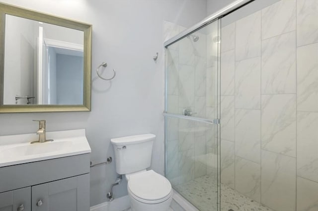 full bathroom with a stall shower, vanity, and toilet