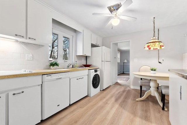 kitchen featuring decorative light fixtures, light hardwood / wood-style flooring, white appliances, washer / clothes dryer, and white cabinets