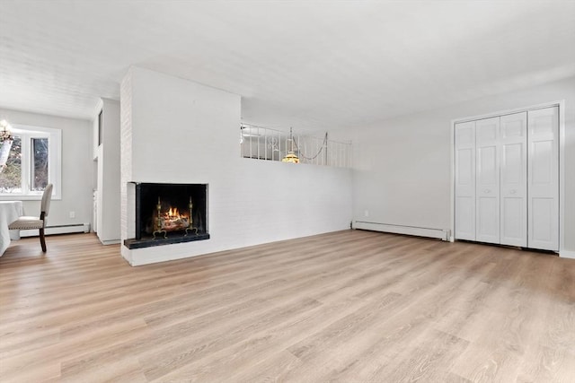 unfurnished living room featuring a brick fireplace, baseboard heating, and light hardwood / wood-style flooring