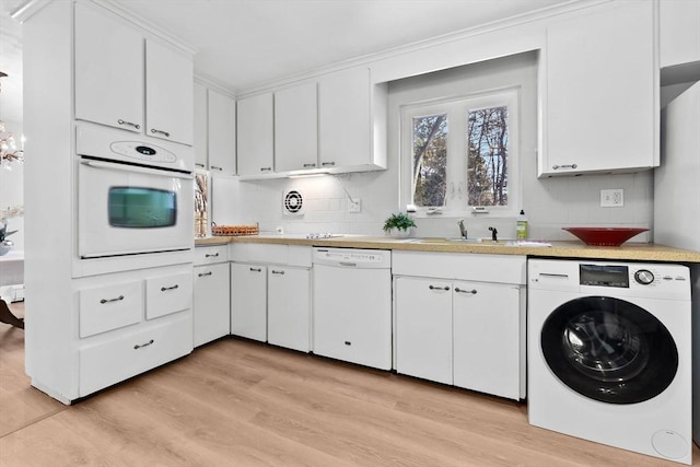 kitchen with washer / dryer, sink, white cabinets, white appliances, and light hardwood / wood-style flooring