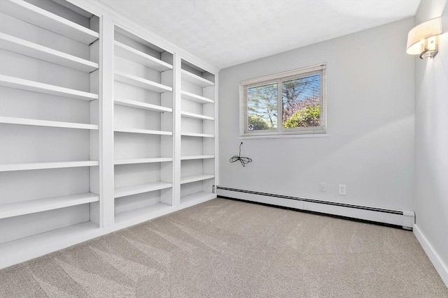 unfurnished room with a baseboard radiator and carpet