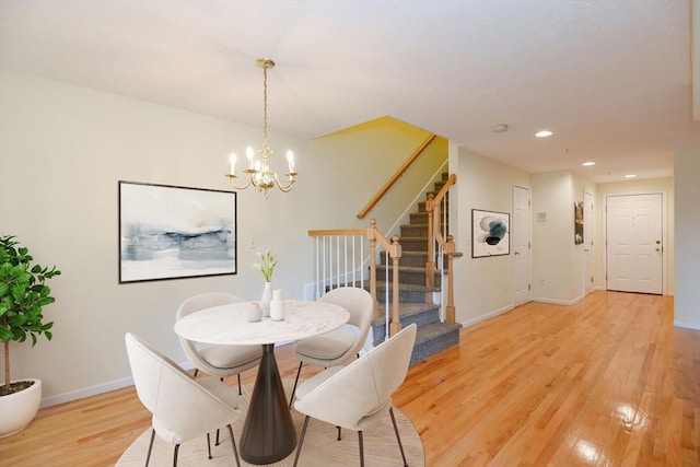 dining area with baseboards, stairway, recessed lighting, light wood-style flooring, and a notable chandelier