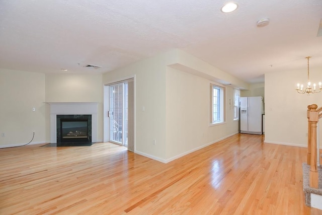 unfurnished living room featuring baseboards, a fireplace, and light wood-style flooring