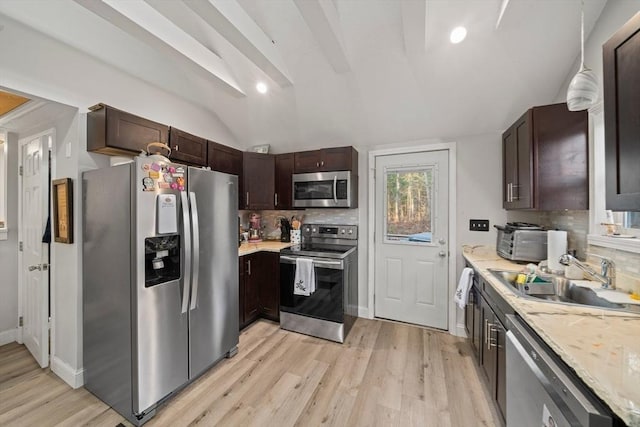 kitchen featuring sink, tasteful backsplash, lofted ceiling, dark brown cabinets, and appliances with stainless steel finishes