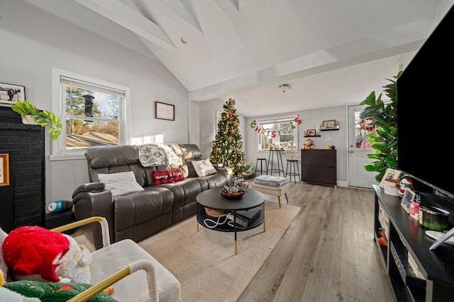 living room with vaulted ceiling with beams and light wood-type flooring