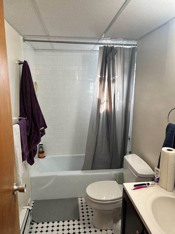 full bathroom with shower / bath combination with curtain, vanity, toilet, and tile patterned floors