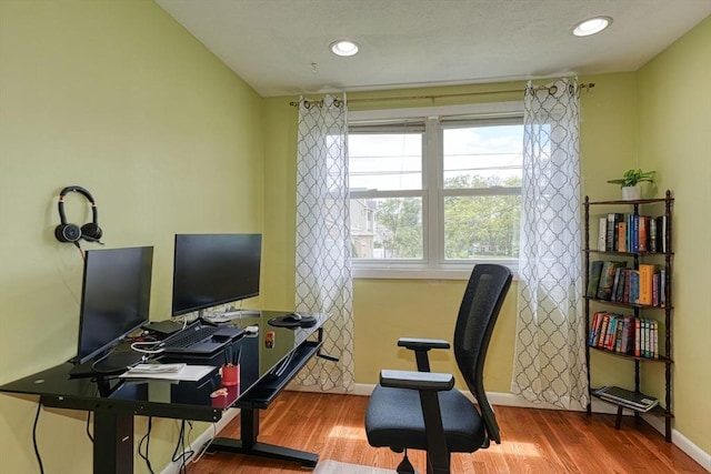 office featuring baseboards, wood finished floors, and recessed lighting