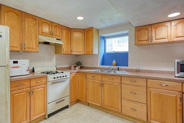 kitchen featuring white appliances, under cabinet range hood, a sink, light countertops, and recessed lighting