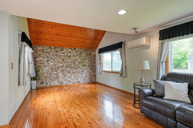 living room with an AC wall unit, lofted ceiling, hardwood / wood-style floors, baseboards, and recessed lighting