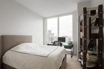 bedroom with a wall of windows and carpet flooring