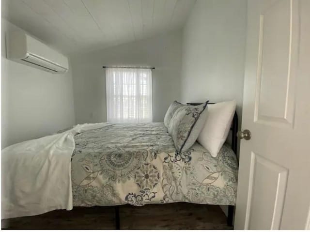 bedroom with vaulted ceiling and a wall unit AC