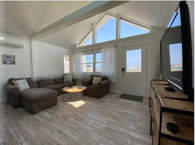 living room featuring beamed ceiling, high vaulted ceiling, a wall unit AC, and light hardwood / wood-style floors