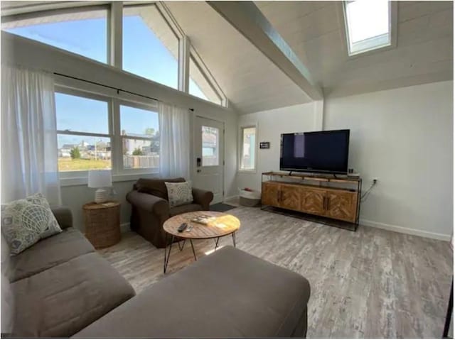 living room with beamed ceiling, high vaulted ceiling, and light hardwood / wood-style floors