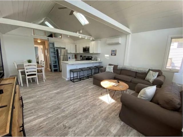 living room featuring wooden ceiling, vaulted ceiling, a wall unit AC, and light wood-type flooring