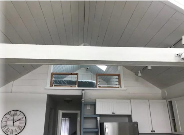 interior details featuring wood ceiling and stainless steel fridge