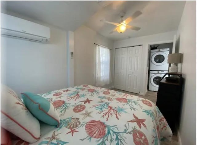 bedroom with stacked washer and dryer, a wall mounted air conditioner, a closet, and ceiling fan