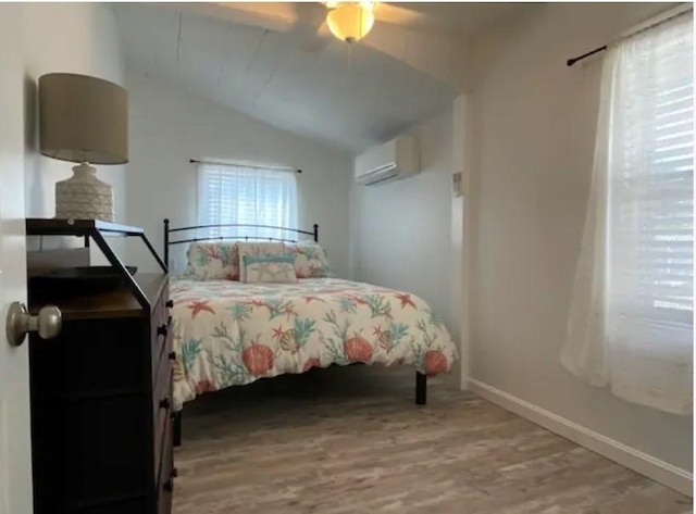 bedroom featuring a wall mounted air conditioner, hardwood / wood-style flooring, vaulted ceiling, and ceiling fan