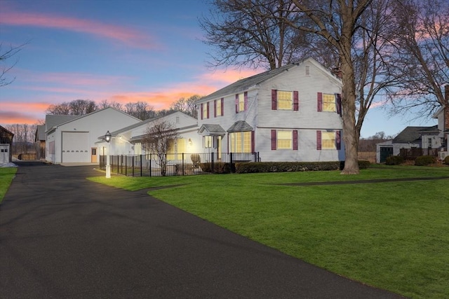 view of front of house with fence, aphalt driveway, a residential view, a yard, and an attached garage