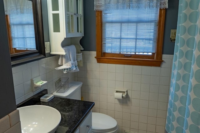 bathroom with vanity, toilet, a healthy amount of sunlight, and walk in shower