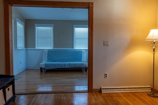 unfurnished room featuring dark hardwood / wood-style flooring, a baseboard radiator, and plenty of natural light