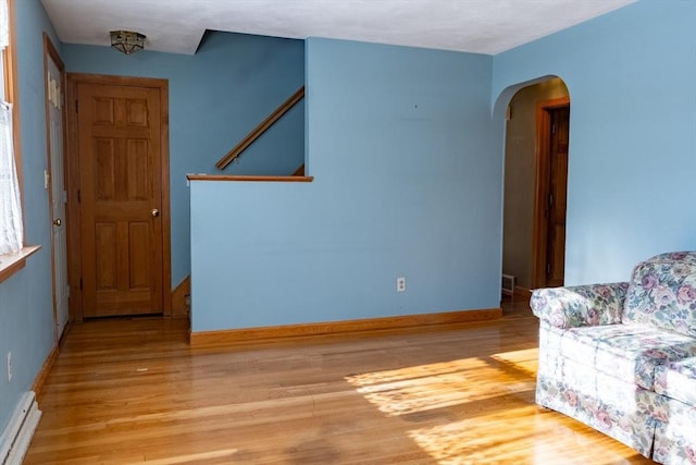 sitting room with a baseboard heating unit and light hardwood / wood-style flooring