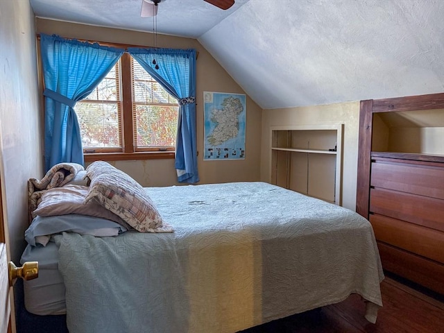 bedroom featuring ceiling fan, lofted ceiling, and a textured ceiling