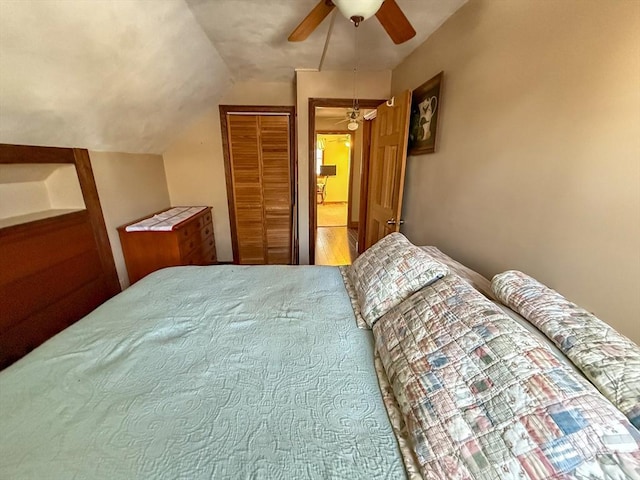 bedroom with ceiling fan, vaulted ceiling, and a closet