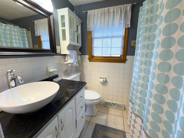 bathroom featuring walk in shower, tile patterned floors, toilet, tile walls, and vanity