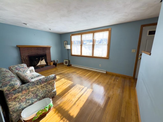 living room featuring a baseboard radiator, wood-type flooring, and a fireplace