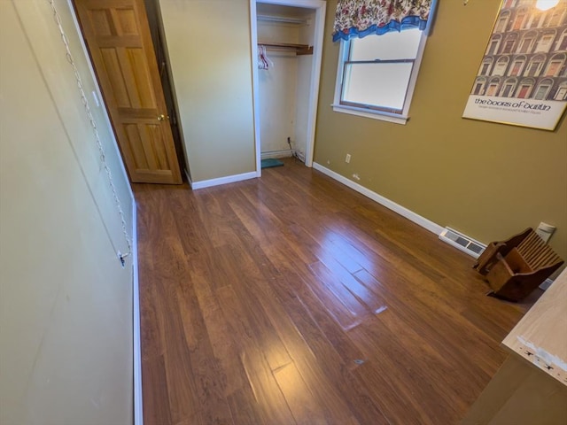 unfurnished bedroom featuring dark hardwood / wood-style floors and a closet