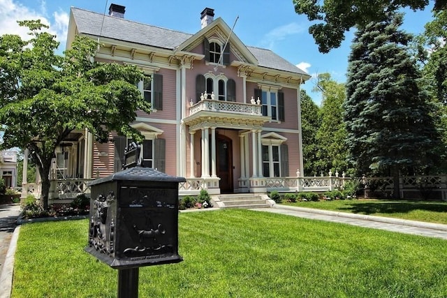 65 Central St, Andover, MA 01810 - italianate home featuring a balcony, covered porch, a front yard, and a chimney