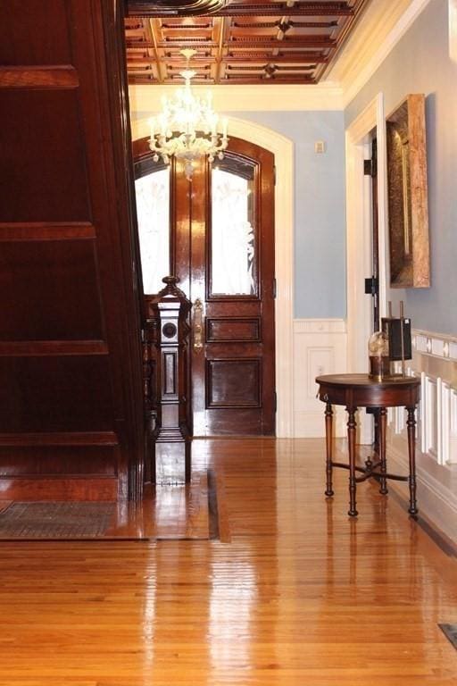 65 Central St, Andover, MA 01810 - corridor with a chandelier, a wainscoted wall, wood finished floors, and ornamental molding