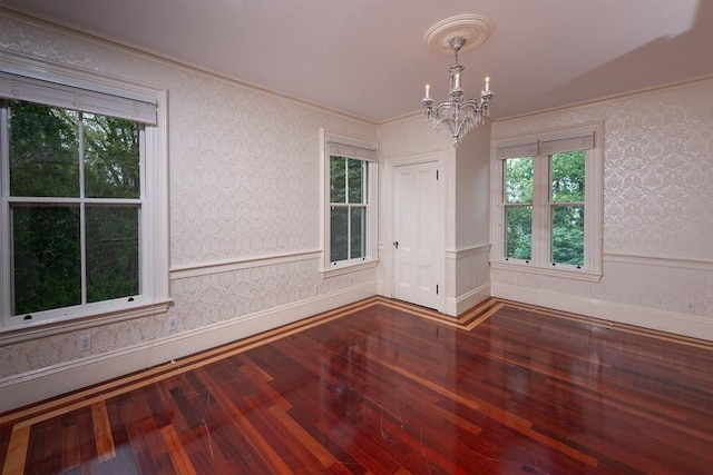 65 Central St, Andover, MA 01810 - spare room featuring a chandelier, hardwood / wood-style floors, ornamental molding, plenty of natural light, and wallpapered walls
