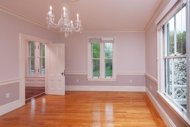 65 Central St, Andover, MA 01810 - spare room featuring a chandelier, light wood-style flooring, crown molding, and baseboards