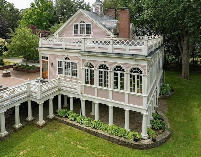 65 Central St, Andover, MA 01810 - back of property with a balcony, a lawn, and a chimney