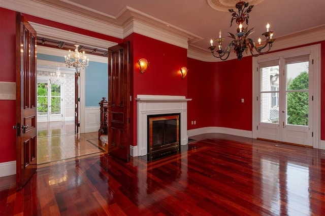 65 Central St, Andover, MA 01810 - unfurnished living room with a chandelier, wood-type flooring, ornamental molding, a fireplace with flush hearth, and baseboards