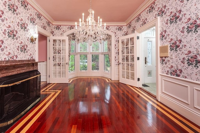 65 Central St, Andover, MA 01810 - unfurnished dining area featuring wallpapered walls, wainscoting, hardwood / wood-style flooring, ornamental molding, and a chandelier