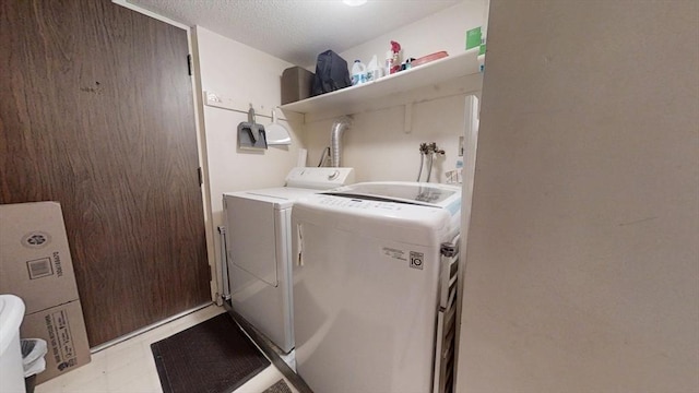 washroom with washing machine and dryer and a textured ceiling