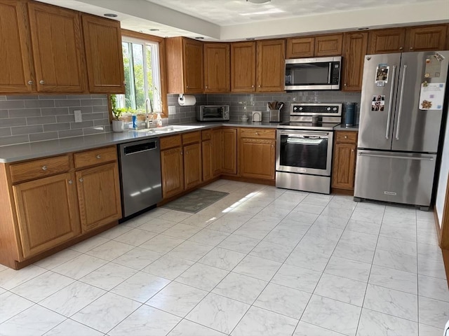 75 Lake St, Rehoboth, MA 02769 - kitchen featuring appliances with stainless steel finishes, a sink, brown cabinetry, and backsplash