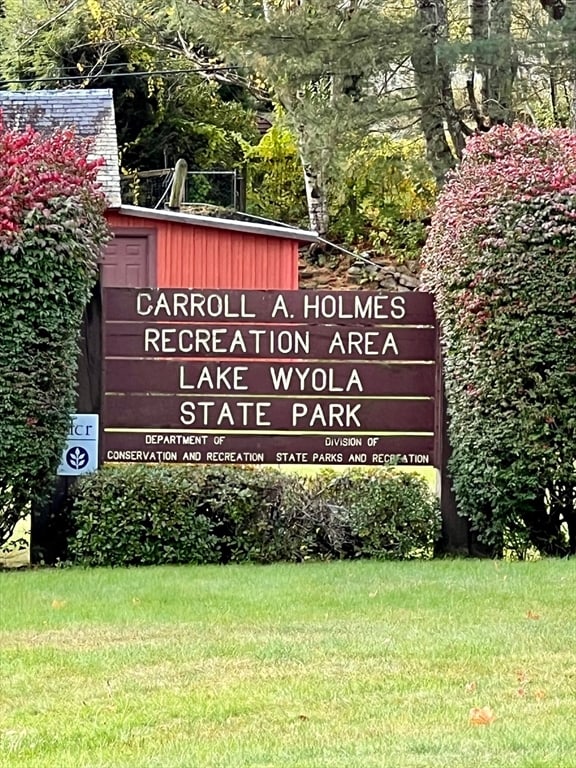 community / neighborhood sign with a yard