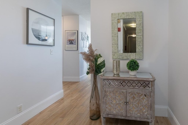 hall featuring wood finished floors and baseboards