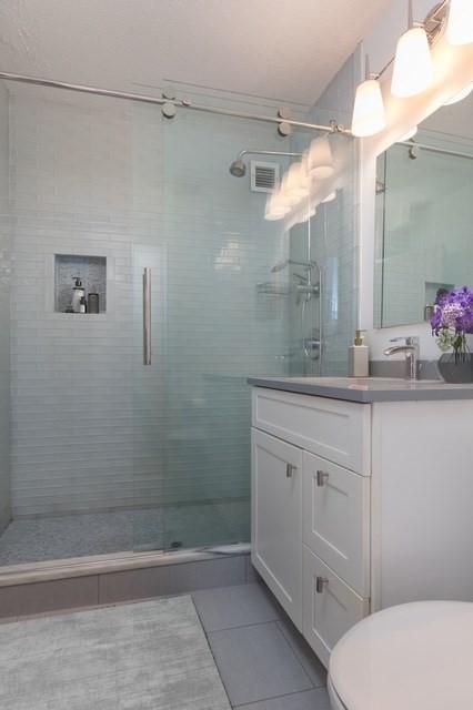 bathroom with tile patterned floors, toilet, and a stall shower