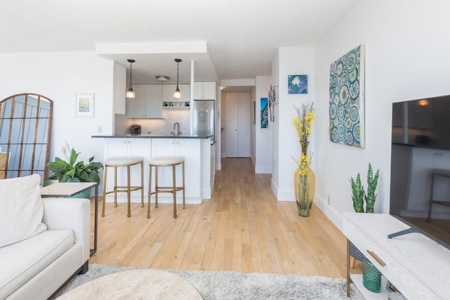 living room featuring light wood finished floors and baseboards
