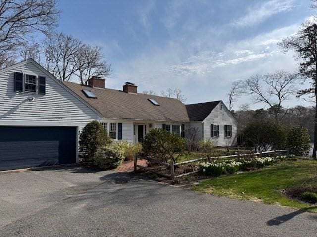 view of front of house featuring driveway and a chimney