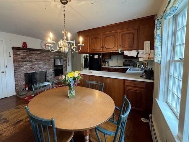 dining space featuring a notable chandelier and a fireplace