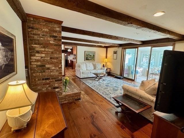 living area with wood-type flooring and beam ceiling