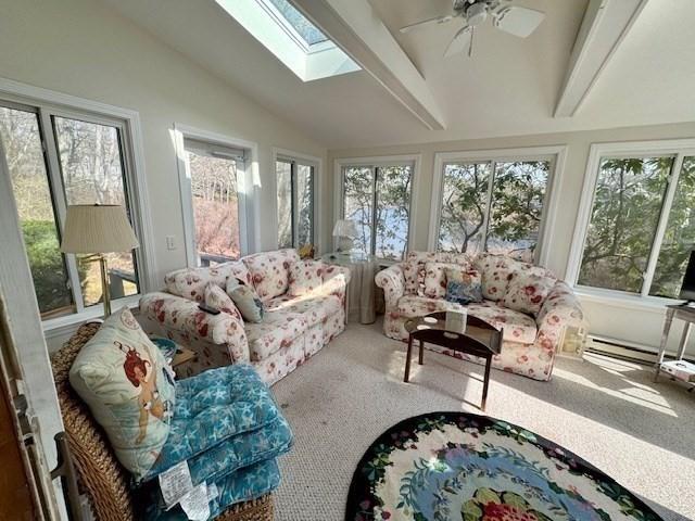 sunroom with carpet and vaulted ceiling with skylight