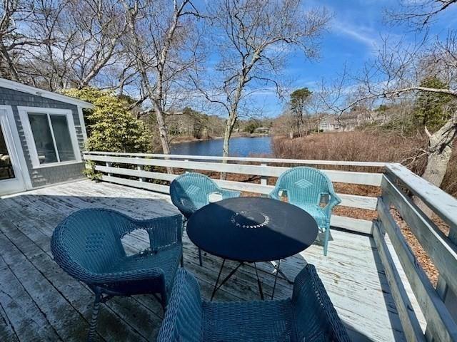 wooden deck featuring a water view and outdoor dining space