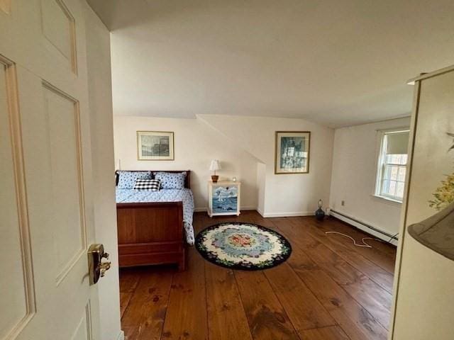 bedroom with baseboards, a baseboard heating unit, and hardwood / wood-style floors